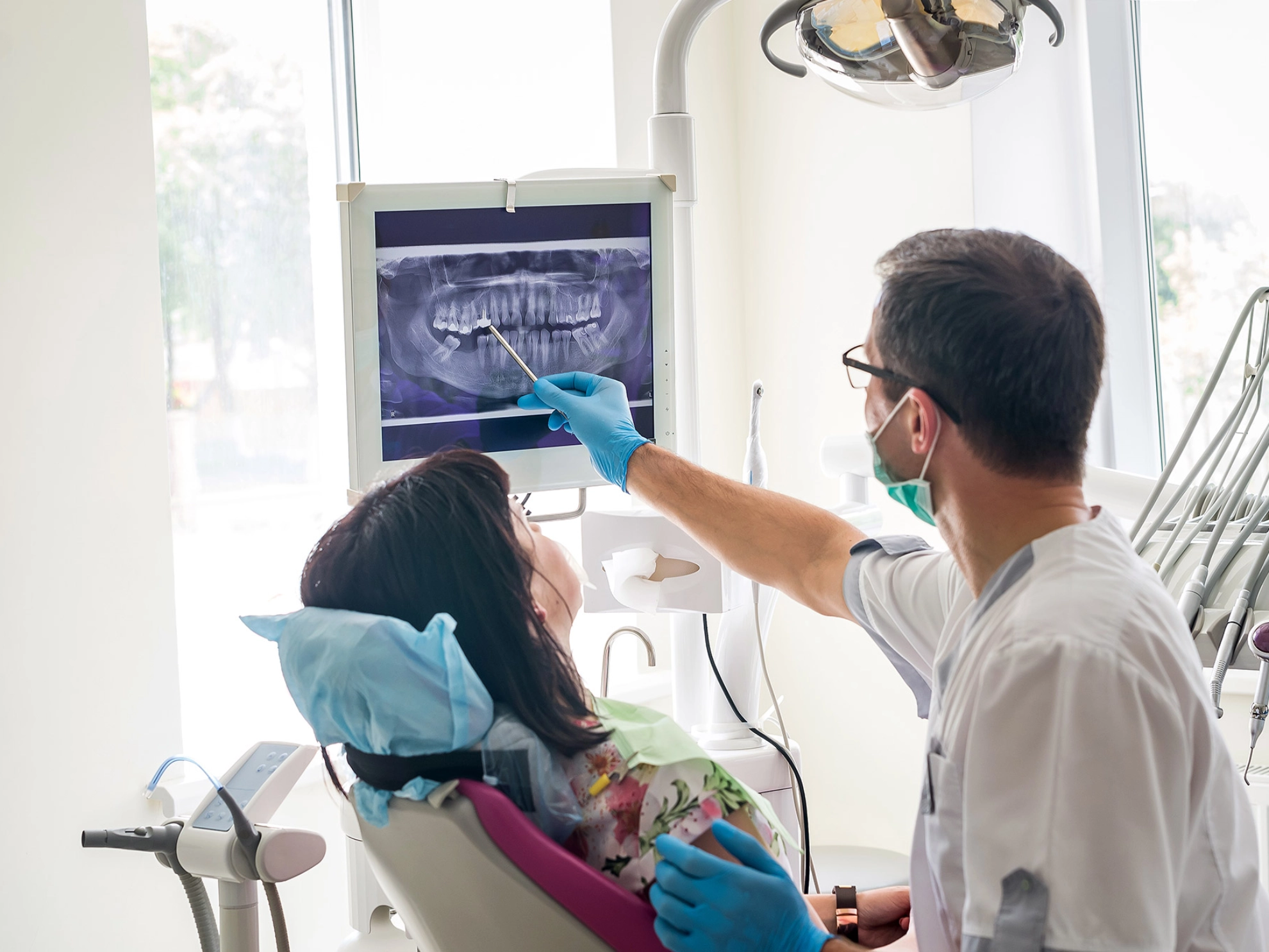 Zahnarzt erklärt einer Patientin das Röntgenbild